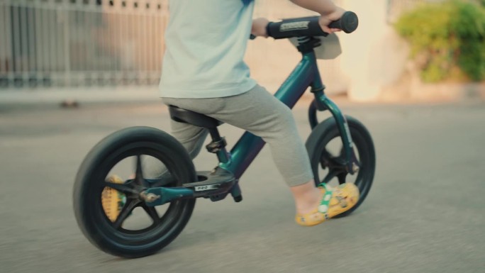 户外探险:精力充沛的男婴在充满活力的城市环境中练习骑自行车技能。