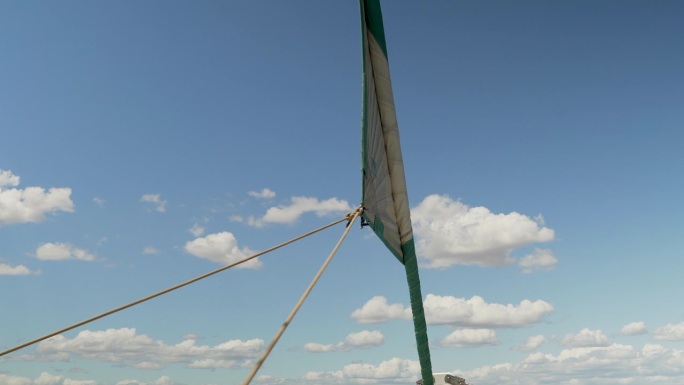 在一个阳光明媚的夏日航行中，帆船的帆被划破了。