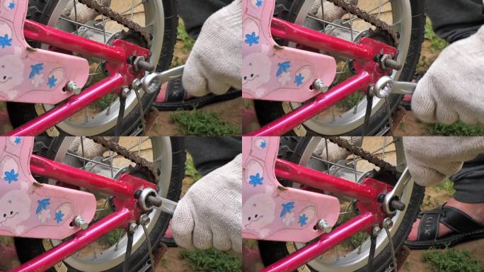 父亲修理了孩子的粉红色自行车，并更换了车轮和链条。一名戴着手套的男子正在修理一辆儿童自行车的小轮子。