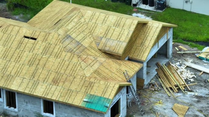 鸟瞰图，在佛罗里达州安静的农村地区，正在建设的木制屋顶框架的郊区私人住宅