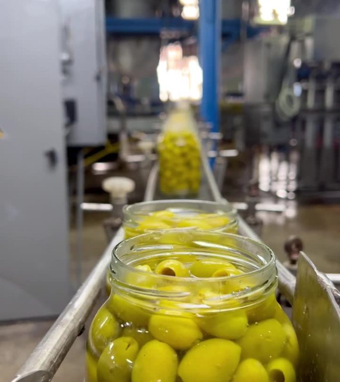 传送带上的罐子里装着橄榄。