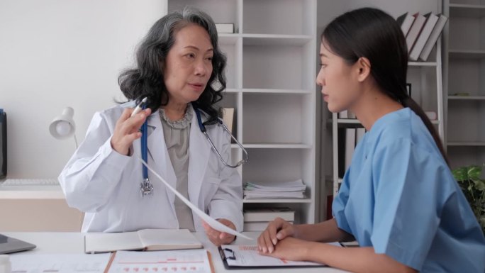 在医院的观察室里，一位资深女医生正在给医科学生提供建议。