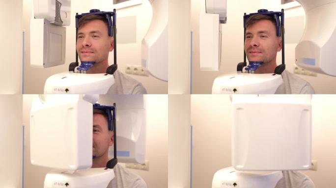 装有头颅测量孔的牙科x光机，一名男子正在拍摄自己的脸部照片。