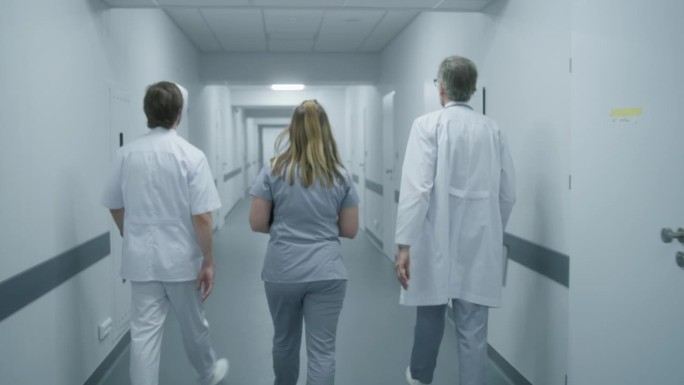 医护人员沿着现代化的诊所走廊行走
