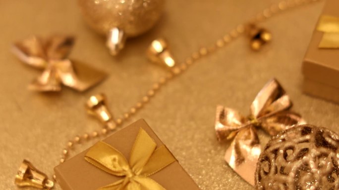 金色背景的圣诞金色玩具、铃铛和礼品盒