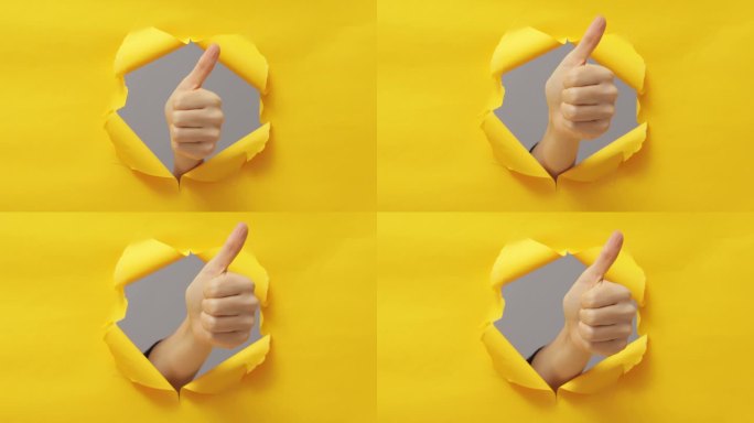 批准。做得很好。超级好。女性伸出大拇指在突破纸洞撕破墙纸在黄色复制空间背景。