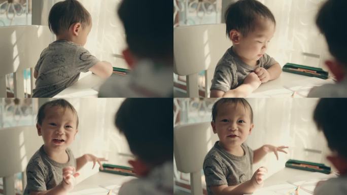 创意家庭教育:两个亚洲兄弟男孩在纸上享受彩色铅笔绘画。