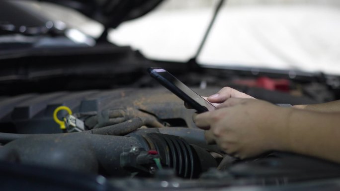 汽车维修技工使用数字设备检查车辆