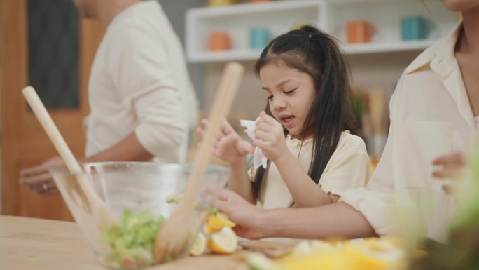 快乐的厨房时刻:亚洲家庭联合一堂有趣的烹饪课程，家长指导孩子制作健康的新鲜蔬菜沙拉。