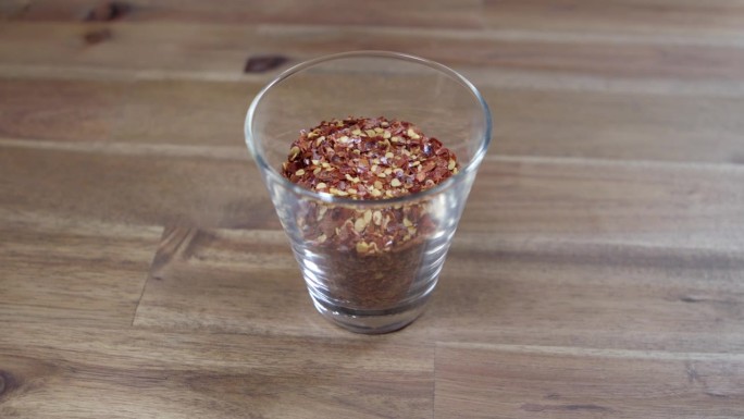 在一个小玻璃容器中研磨干辣椒，这是阿根廷辣酱必不可少的原料