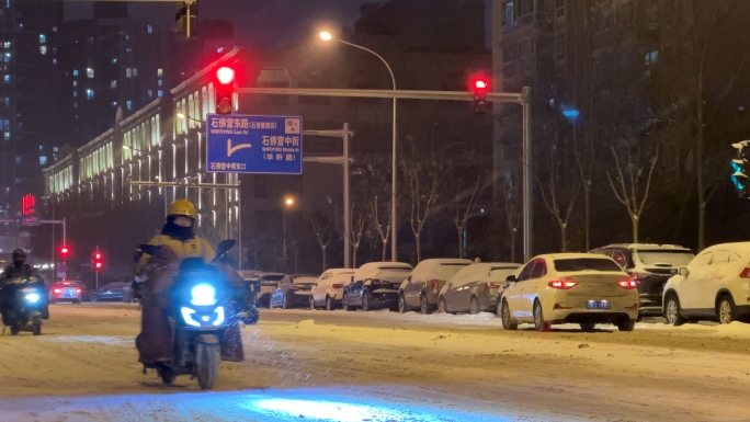 北京降雪天气夜间城市道路汽车行人外卖小哥