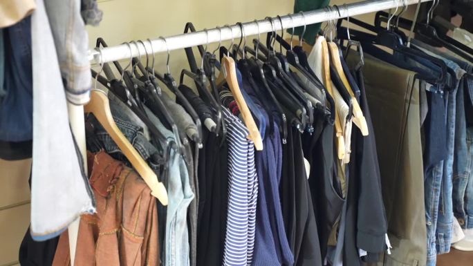 在专业的工作室车间里摆满衣架的衣架，由裁缝修补的一系列服装，在车间里修补的布料
