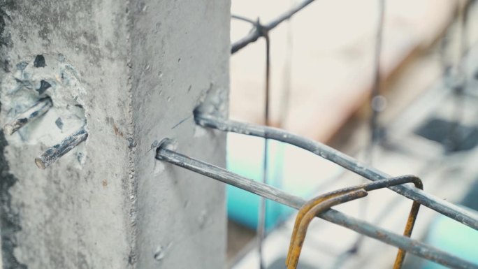 建筑工人将钢筋与钢筋网连接起来，作为线材建筑板的一部分，金属结构在现场退火钢捆绑，在室外建造房屋的工