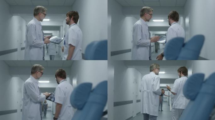 男医生在诊所走廊的平板上向同事展示MRI扫描图像