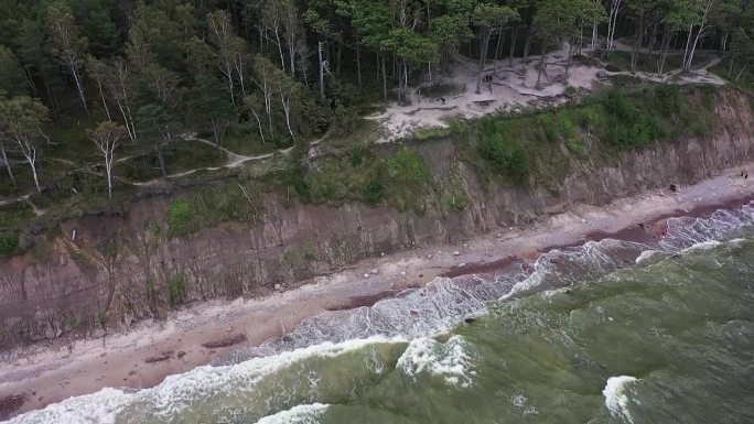 一架无人驾驶飞机揭开了立陶宛波罗的海悬崖海岸的宏伟景象，在那里，气势汹汹的海浪撞击着岩石，周围是喜怒