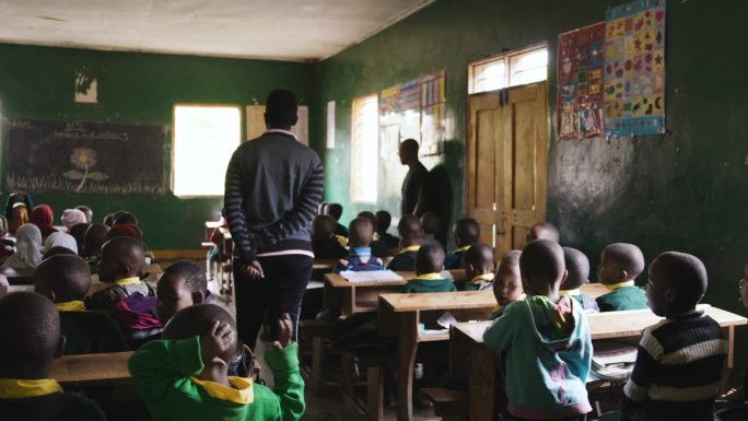 从门口看到孩子们在教室里的手持照片。男孩和女孩在学校学习。他们在教育大楼里。