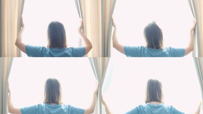 年轻女子站在窗前，拉开窗帘，从后面看。