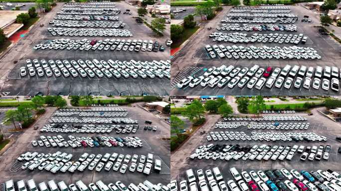 在一个停满了无标志警车的停车场上空低空飞行，黑色、白色和银色的车辆。