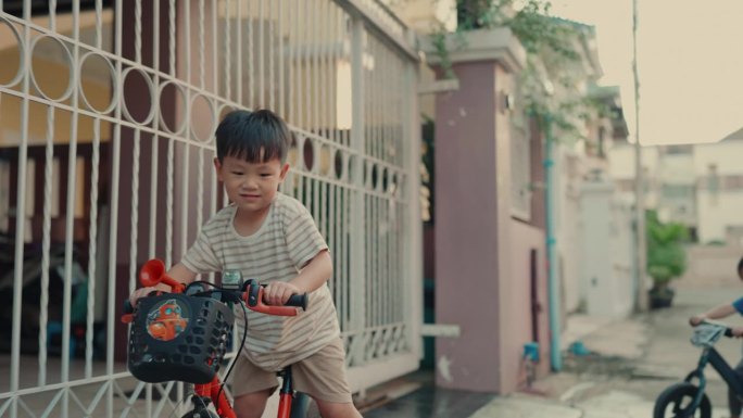 无忧无虑的童年时刻:活跃的亚洲孩子在城市街道上快乐地骑自行车。