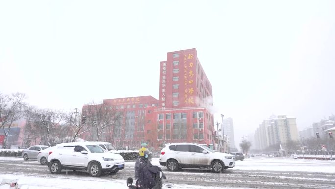 下雪天汽车和行人在等红绿灯