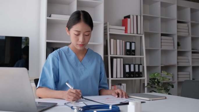 图为，一名亚洲女医科学生在医院大厅用笔记本电脑学习医学教科书。