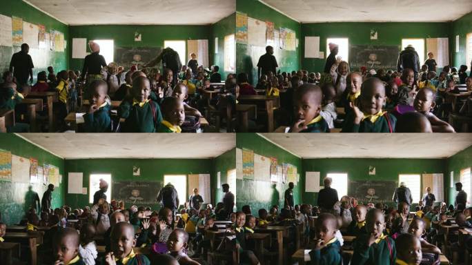 学生在教室里对着镜头挥手的慢动作镜头。孩子们与老师和志愿者在学校。教育大楼内部。教育是一项基本人权，