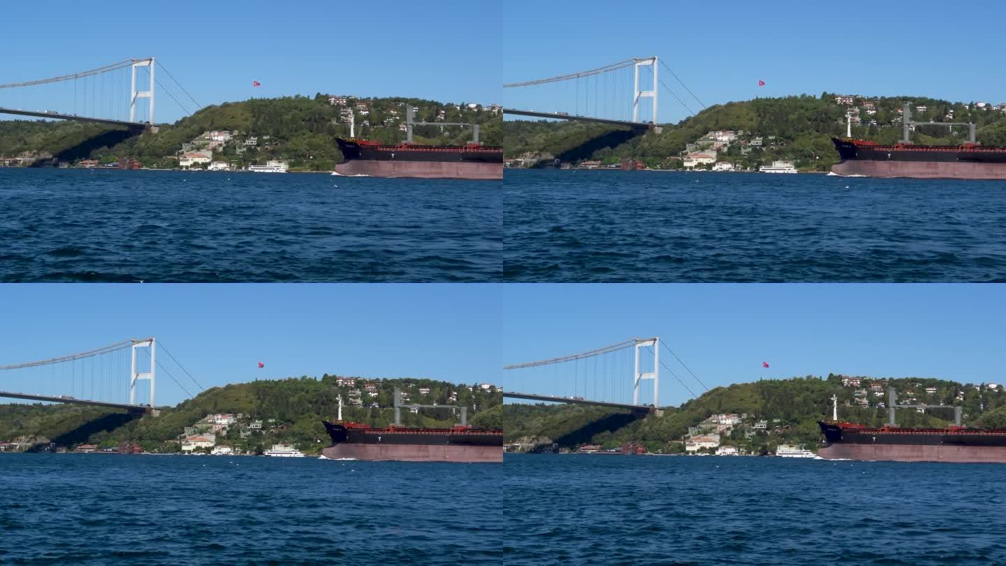 货船经过土耳其伊斯坦布尔博斯普鲁斯海峡法提赫苏丹穆罕默德大桥下