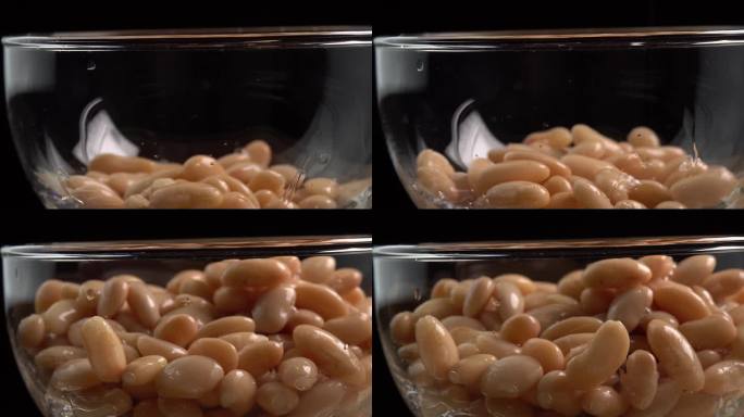 白芸豆罐头倒在玻璃碗里。墨西哥菜的腌豆。有机蒸豆