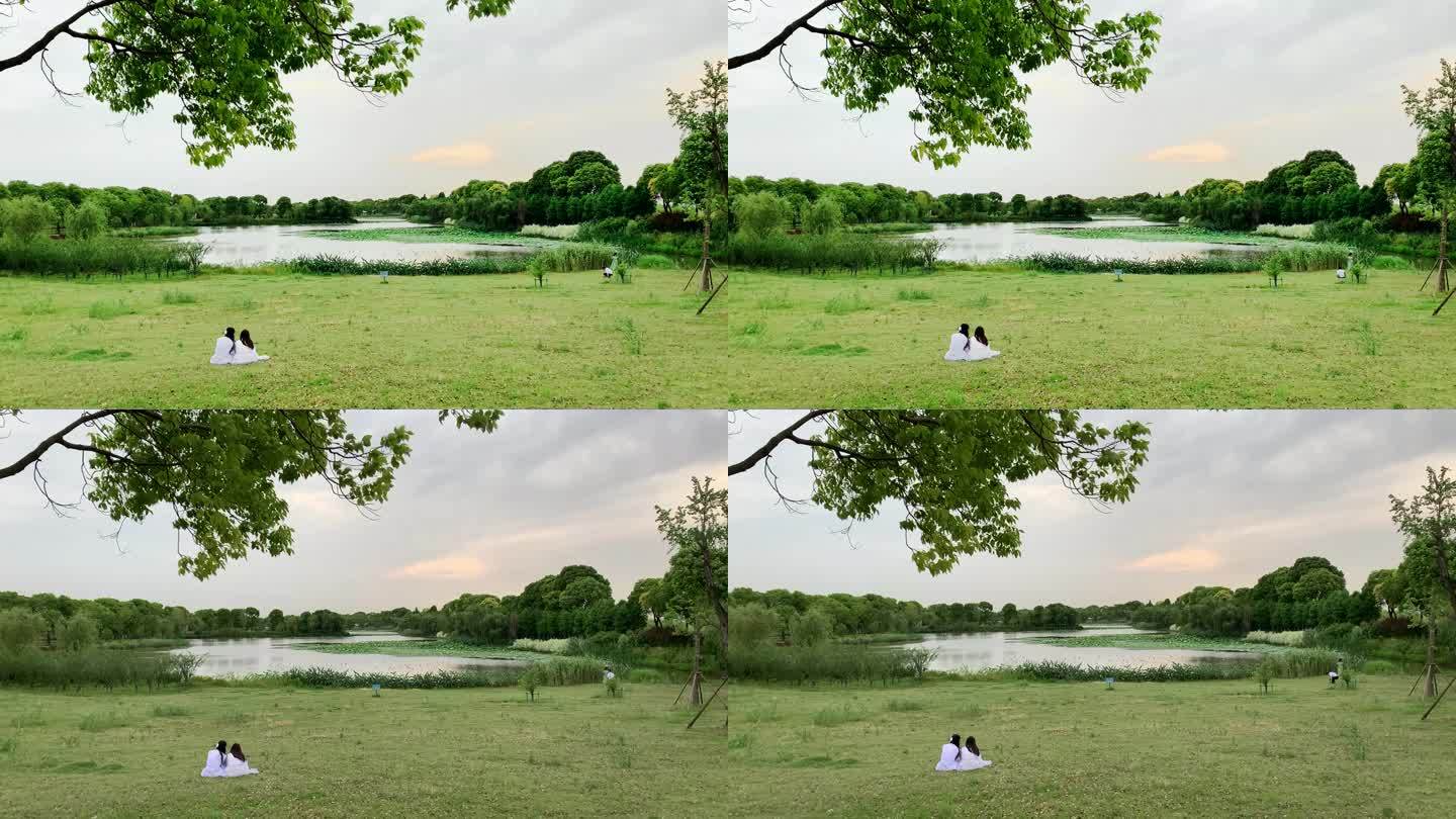 坐在草地上的两个人背影