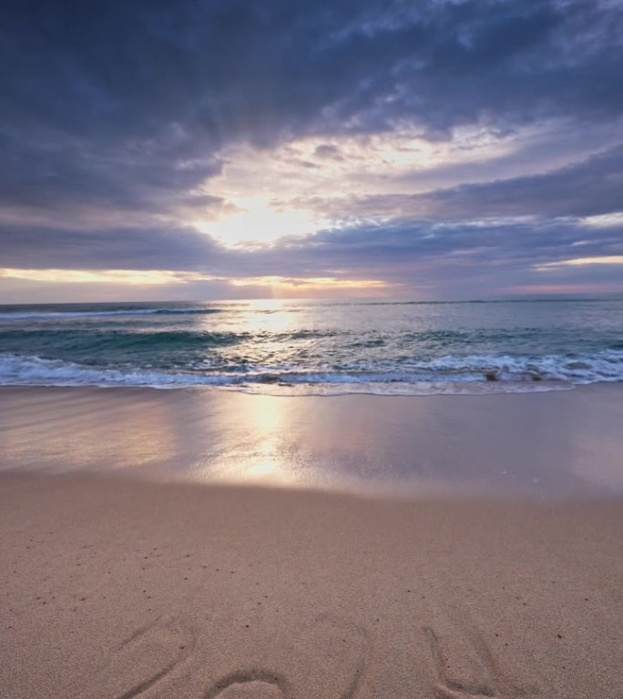 2024年新年文字上的海沙和美丽的沙滩日出垂直视频