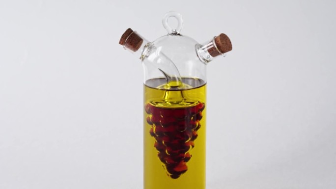 装有橄榄油和葡萄酒醋的玻璃罐，软木盖孤立在白色背景上