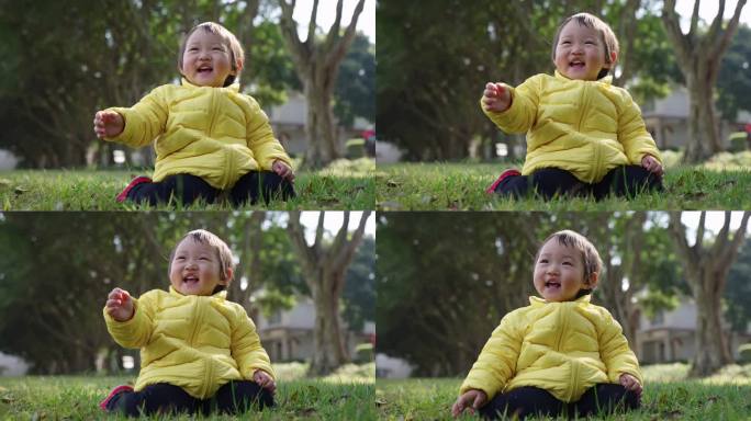 穿鸭黄羽绒服的小女孩坐在早春公园草地微笑