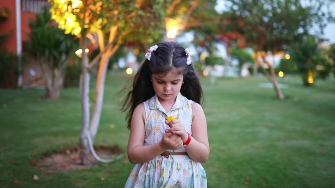 小女孩在花园里捧着一朵黄花