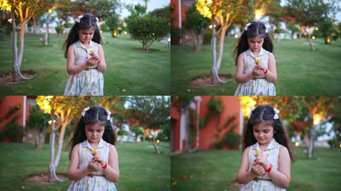 小女孩在花园里捧着一朵黄花