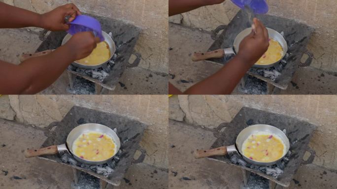 一名非洲妇女在炭炉上用煎锅做煎蛋，配上一道加纳菜班库