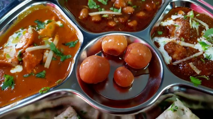 印度著名的咖喱装在银盘里，配上泡菜、黄油、鸡肉和印度沙拉