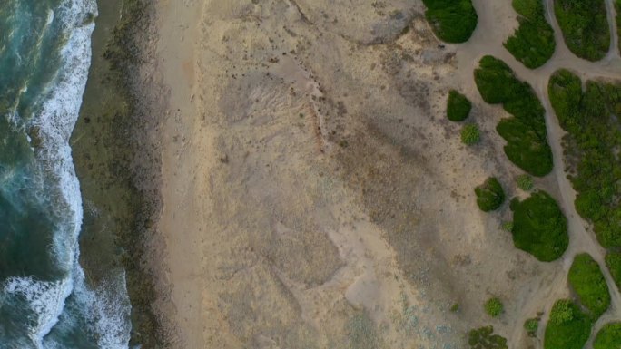 空中无人机俯瞰佛得角海岸，海浪冲击着意大利撒丁岛的狂野海滩