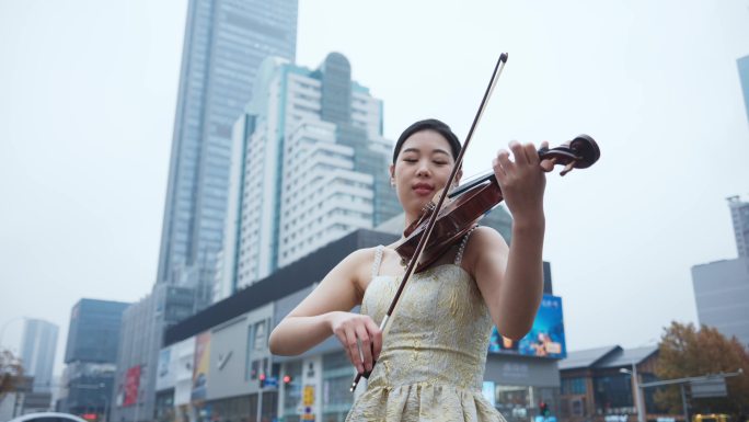 美女在城市街头拉小提琴