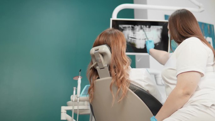 牙医会向病人详细解释x光检查的结果和治疗方案。病人认真而有兴趣地聆听牙医的建议。