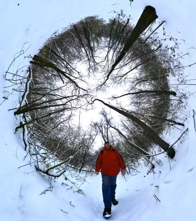 一名身穿红色夹克的男子走过冬天积雪的森林