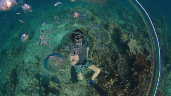 自由潜水员在水下制造环状气泡并与之玩耍