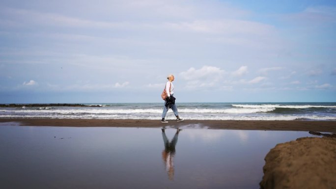 女人走在海边的海岸线上