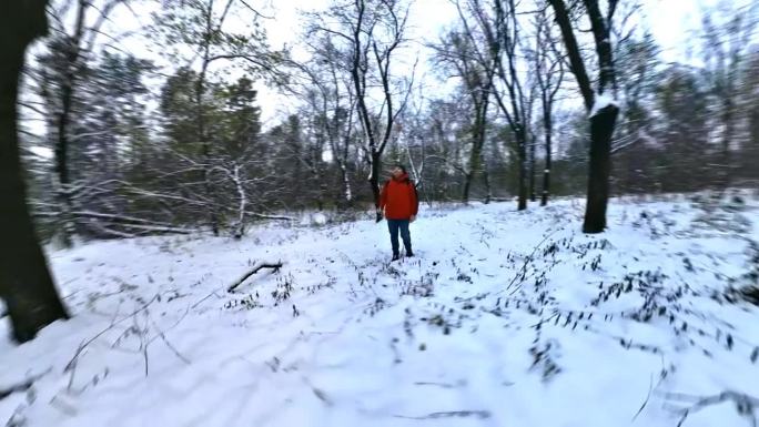 穿红夹克的男人欣赏冬天的雪林