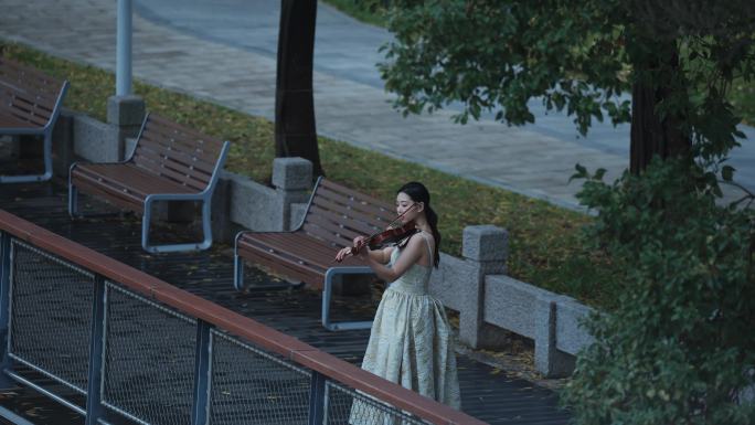 美女在河边拉小提琴