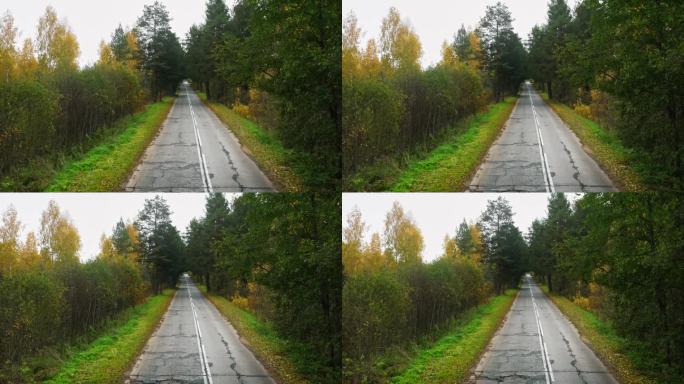 秋天的过渡，雪花轻轻地点缀着落叶散落的公路。无人机航拍