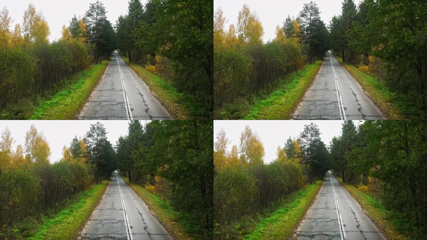 秋天的过渡，雪花轻轻地点缀着落叶散落的公路。无人机航拍