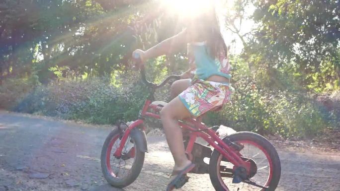 小女孩在公园里骑自行车。