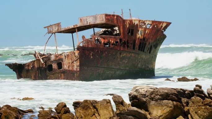 锈迹斑斑的沉船残骸卡在崎岖的阿古拉斯角海岸线的浅滩上