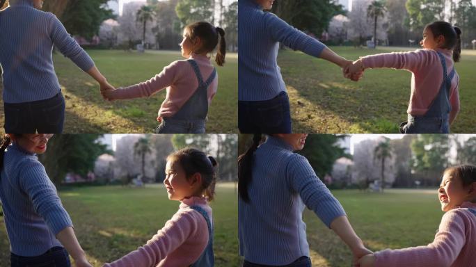 小女孩和妈妈牵手走在公园散步亲子陪伴