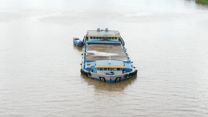 桑驳船矿装载着沙子停泊在湄公河沿岸